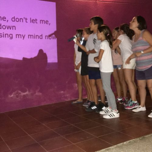 Grupo de niños cantando karaoke de canción en inglés