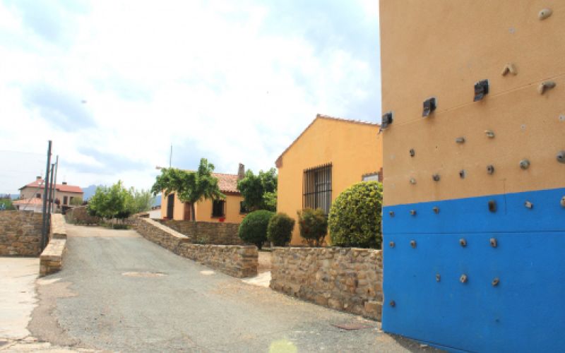 Detalle de pared del albergue en color azul y ocre con rocódromo